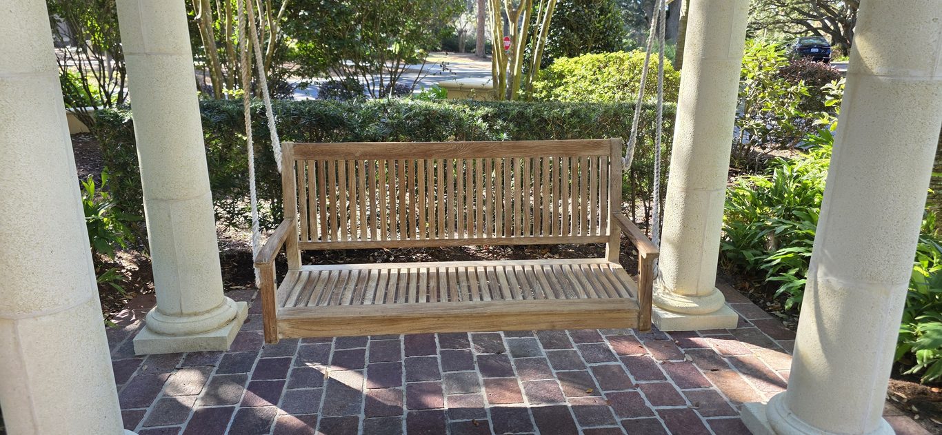 Cleaned teak porch swing between columns in Hilton Head, SC